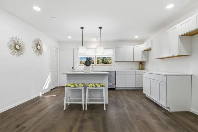 a kitchen with a table chairs refrigerator and cabinets