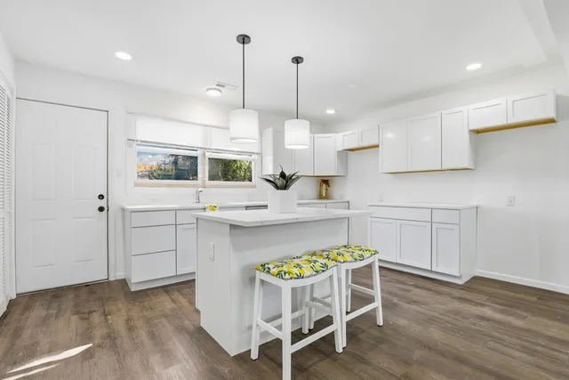 a kitchen with a table chairs refrigerator and microwave