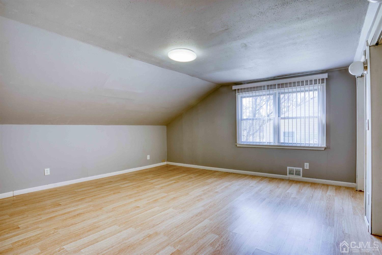 19 Hill Road Edison, NJ 08817 - Photo 14 of 19 a view of an empty room with wooden floor and a window