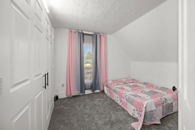 a bedroom with a bed and a painting on the wall