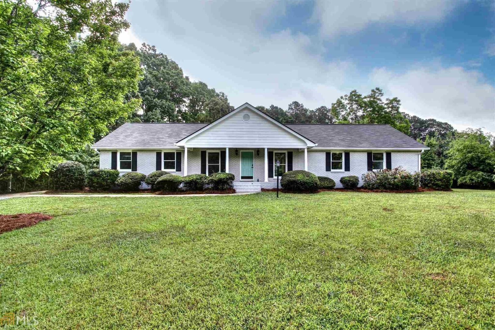 a front view of a house with a yard and trees