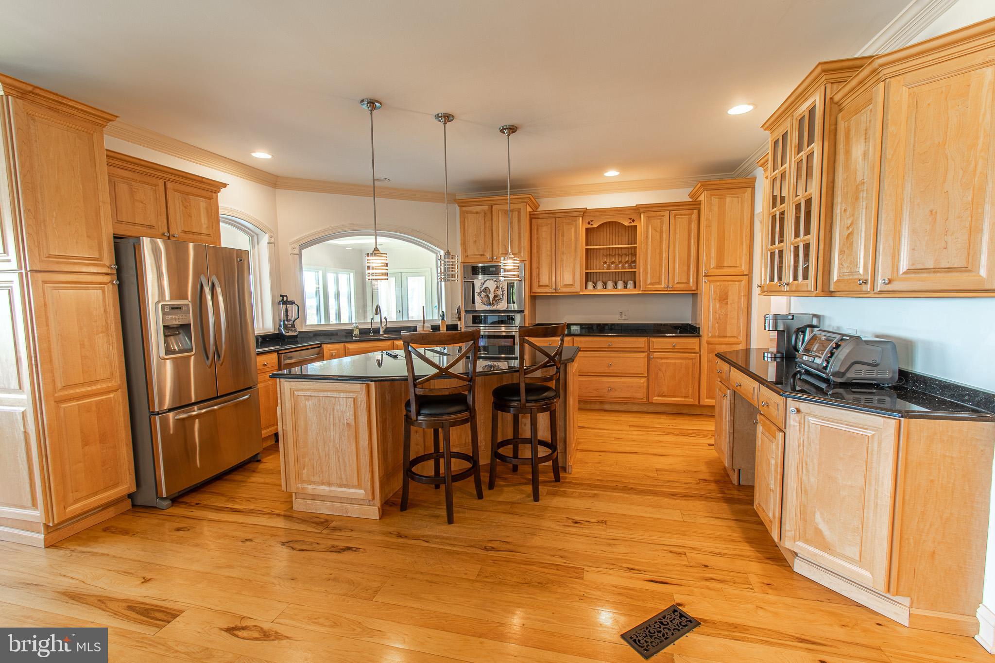 5227 Brooks Road Woolford, MD 21677 - Photo 16 of 68 a kitchen with stainless steel appliances granite countertop a refrigerator a sink a stove and a wooden floors