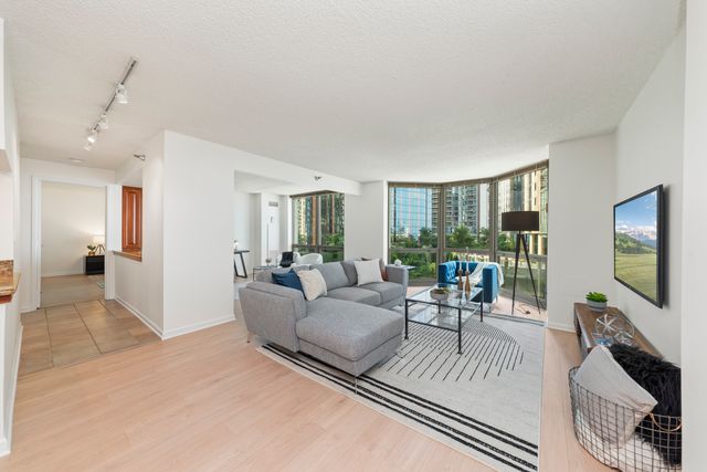 a living room with furniture a flat screen tv and a large window