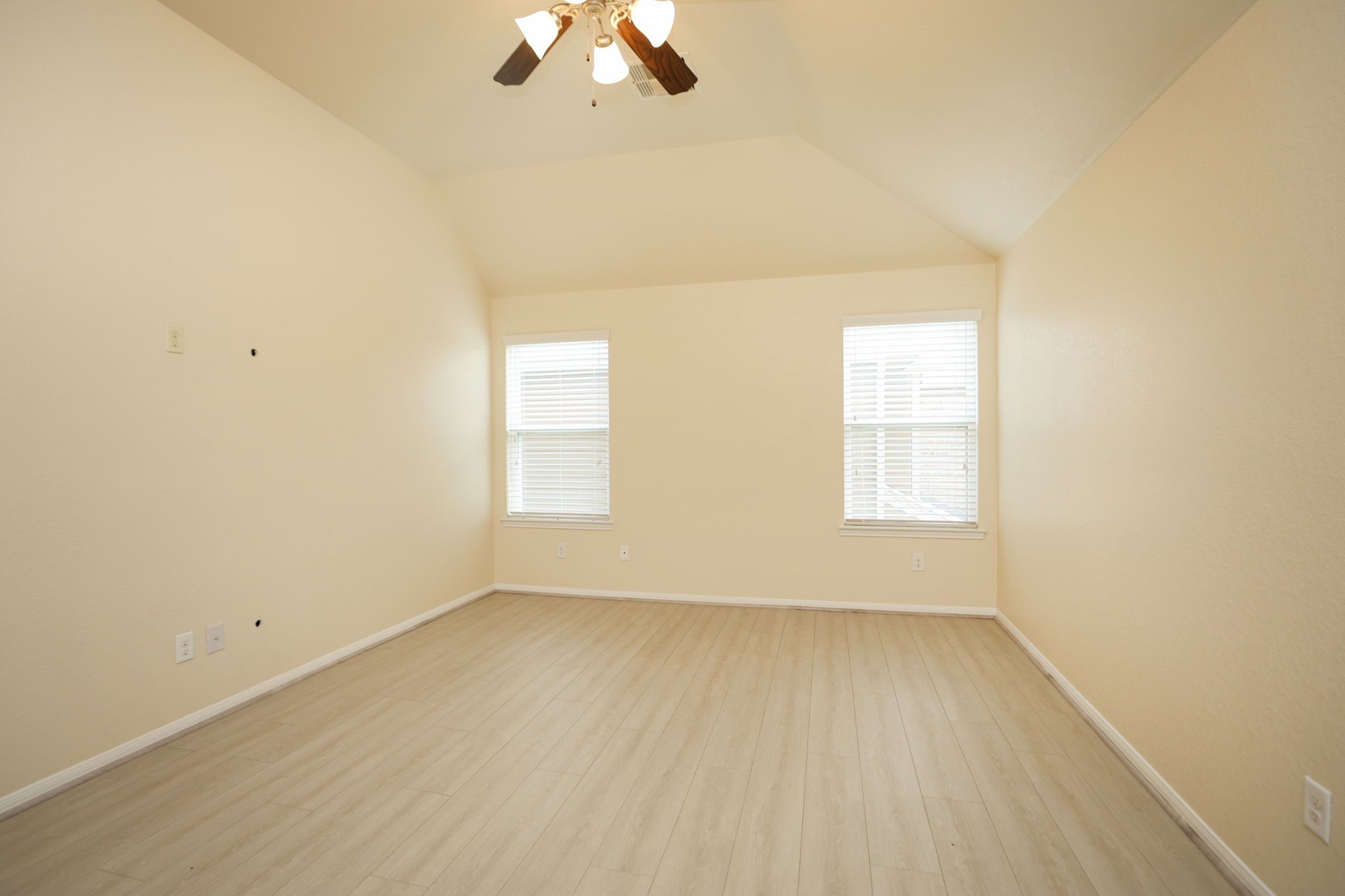 18402 Spruce Tree Line Trail Houston, TX 77084 - Photo 16 of 30 A bright, spacious room with light-colored walls and flooring, featuring a high ceiling with a fan and two large windows for natural light.