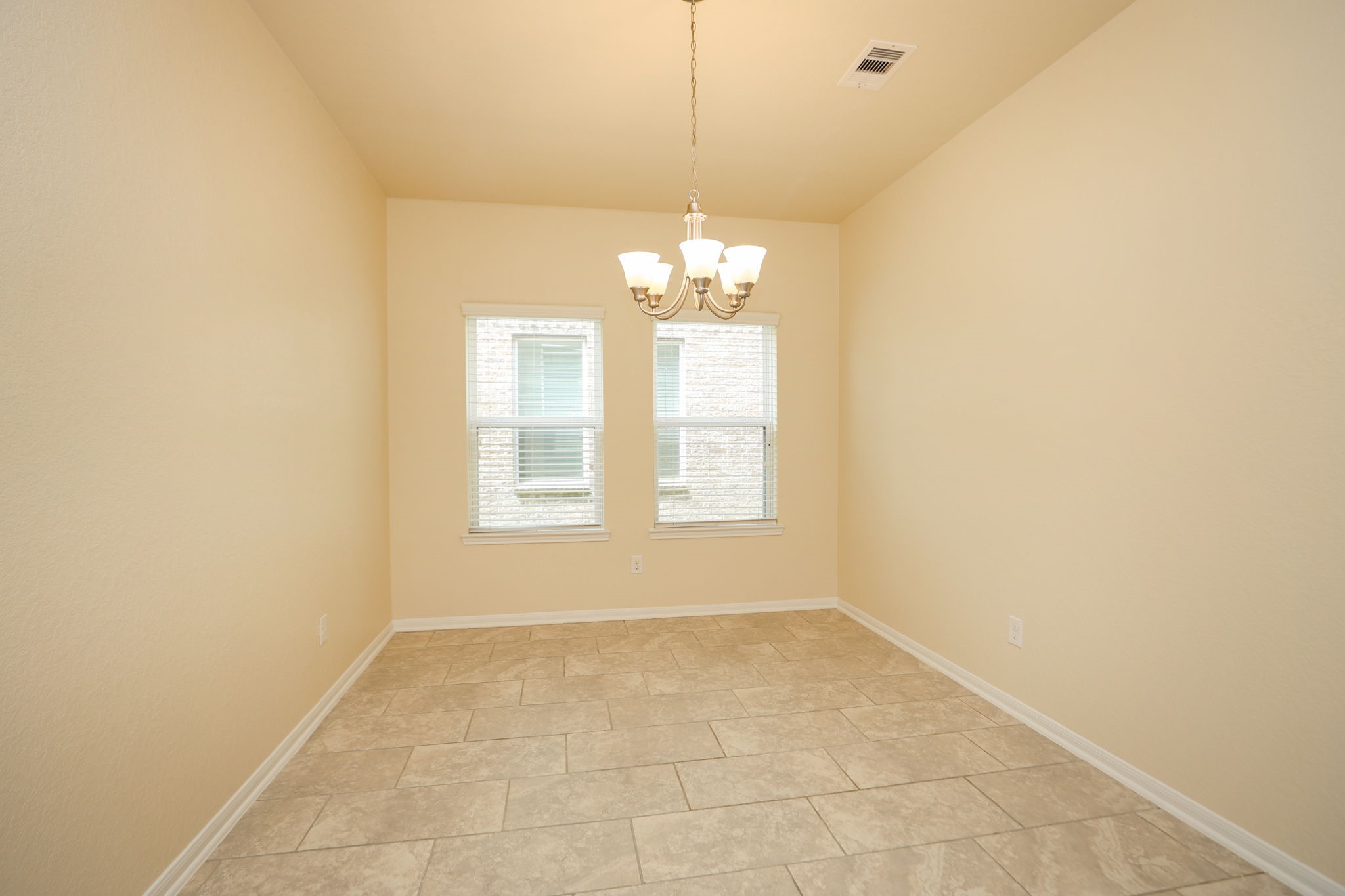 18402 Spruce Tree Line Trail Houston, TX 77084 - Photo 10 of 30 This room features neutral walls, tile flooring, and two windows allowing natural light. A ceiling light fixture adds elegance, making it ideal for a dining area or office space.