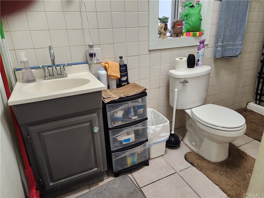 4466 11th Street Riverside, CA 92501 - Photo 15 of 17 a bathroom with a sink toilet and a mirror