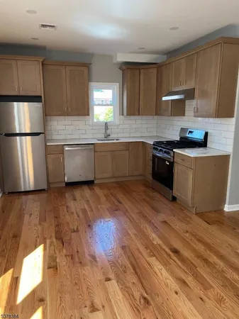 a kitchen with stainless steel appliances wooden floors and wooden cabinets