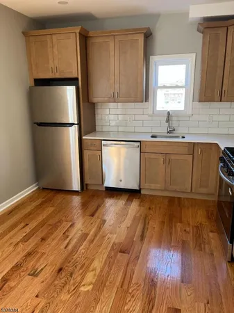a kitchen with granite countertop white cabinets and wooden floor