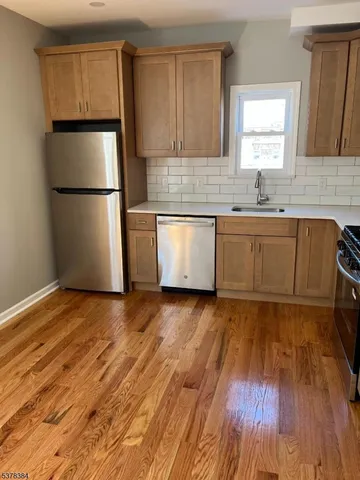 a kitchen with granite countertop white cabinets and wooden floor
