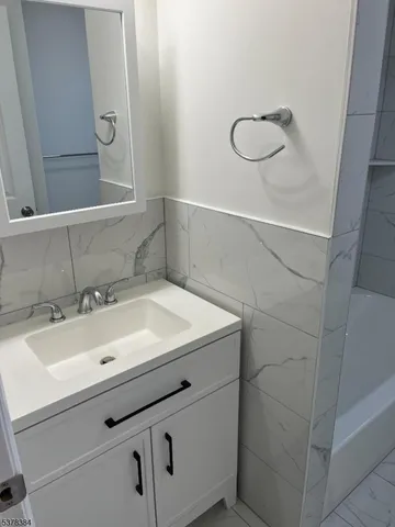 a bathroom with a sink vanity and a mirror