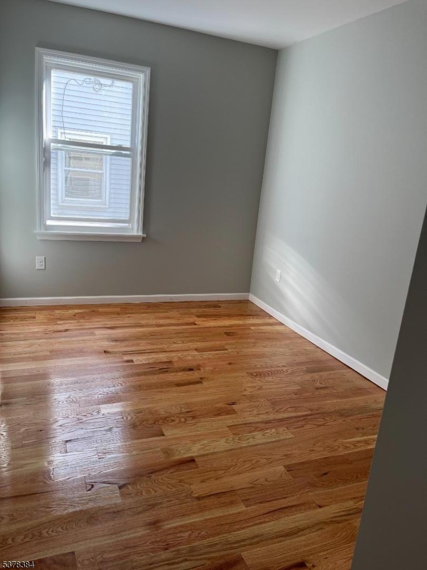433 Rosehill Place, Unit 3 Elizabeth, NJ 07202 - Photo 3 of 13 an empty room with wooden floor and windows