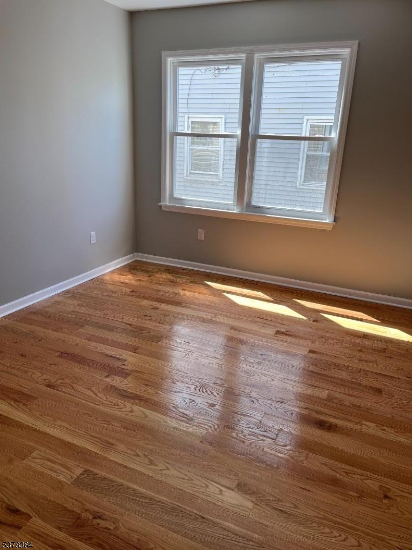 433 Rosehill Place, Unit 3 Elizabeth, NJ 07202 - Photo 10 of 13 an empty room with wooden floor and windows