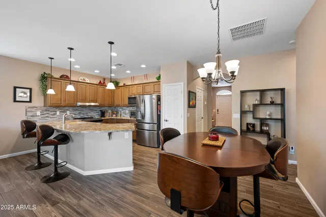 a dining room filled chandelier and wooden floor
