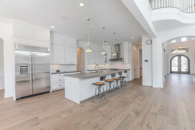 an empty room with wooden floor cabinet and windows