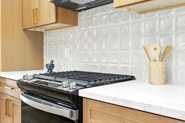 a kitchen with a sink dishwasher stove and white cabinets