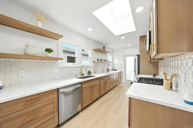 a kitchen with stainless steel appliances granite countertop a stove a sink and a refrigerator