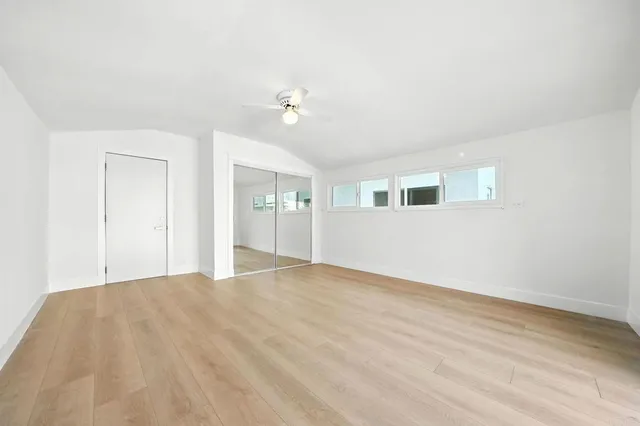 a bedroom with a bed and a potted plant on dresser