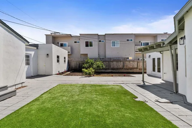 a view of a white house with a potted plant