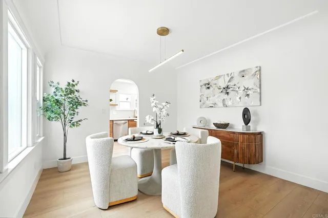 a living room with furniture a potted plant and a large window