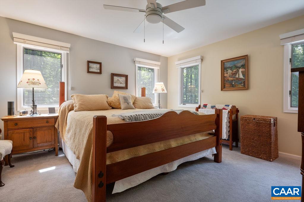 2110 Whippoorwill Road Charlottesville, VA 22901 - Photo 15 of 37 a bedroom with a bed and a chandelier