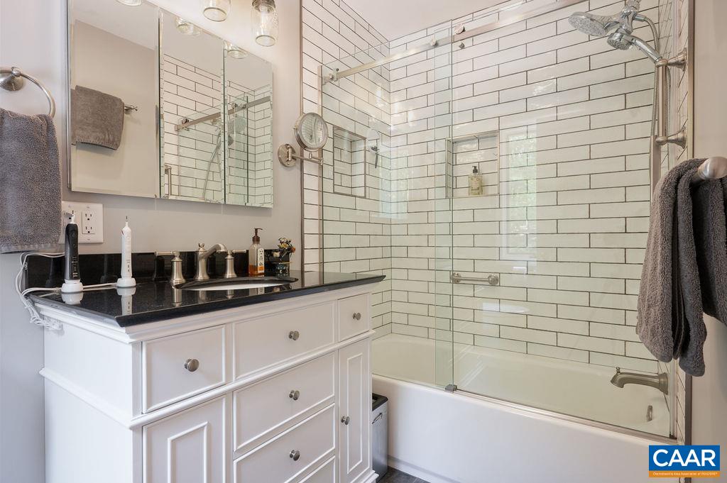 2110 Whippoorwill Road Charlottesville, VA 22901 - Photo 16 of 37 a bathroom with a granite countertop sink a toilet and bathtub