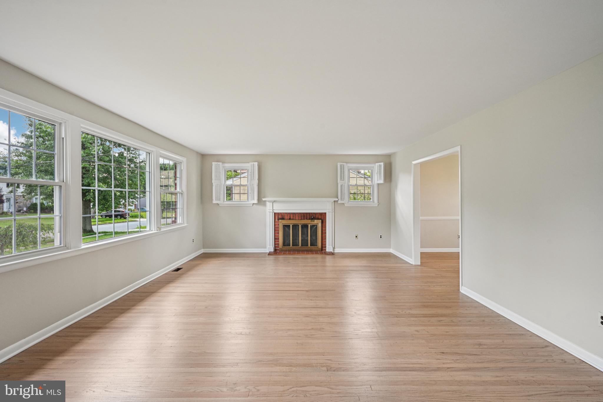 143 Ashbrook Road Cherry Hill, NJ 08034 - Photo 7 of 40 an empty room with wooden floor fireplace and windows