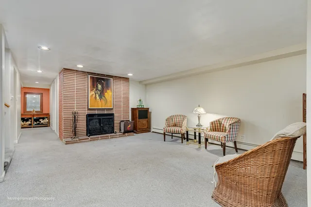 a living room with furniture and a flat screen tv with kitchen view