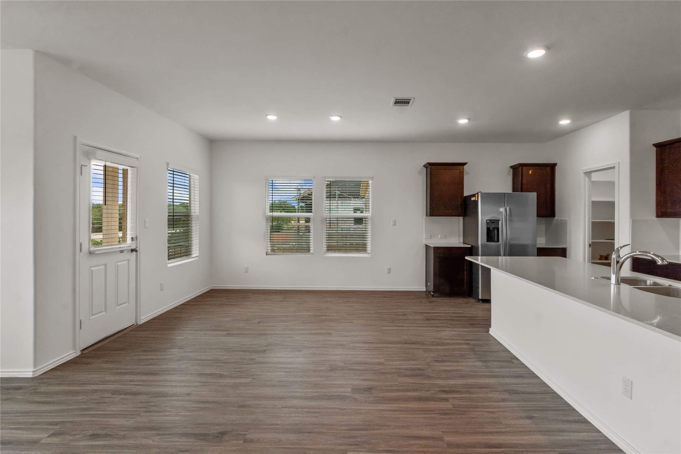 1108 Mallow Road Leander, TX 78641 - Photo 7 of 30 An open-concept living area seamlessly connects to the kitchen over durable wood-look flooring.