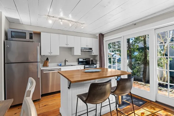 a kitchen with stainless steel appliances granite countertop a refrigerator a stove top oven a sink dishwasher and white cabinets