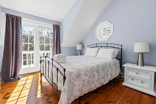 a bedroom with a bed and a large window
