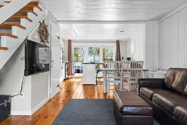 a living room with furniture flat screen tv and a large window
