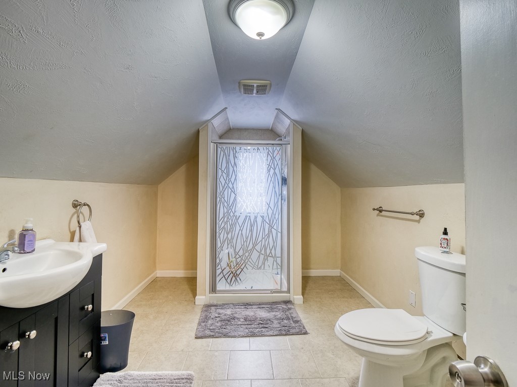 6794 York Road Cleveland, OH 44130 - Photo 30 of 45 Bathroom with vanity, a textured ceiling, light tile patterned floors, and lofted ceiling