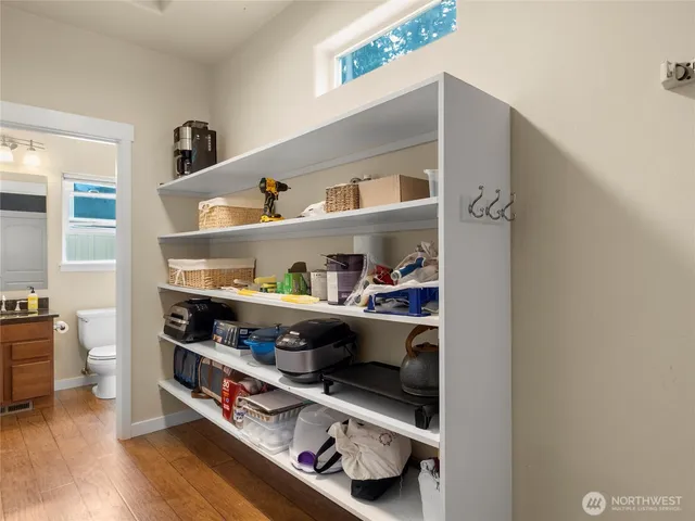 a kitchen with a wooden floor and lots of stainless steel appliances
