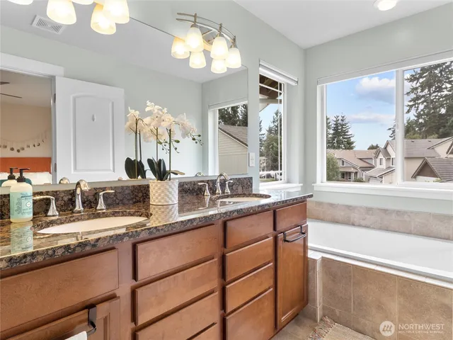 a bathroom with a granite countertop sink a large mirror and a window