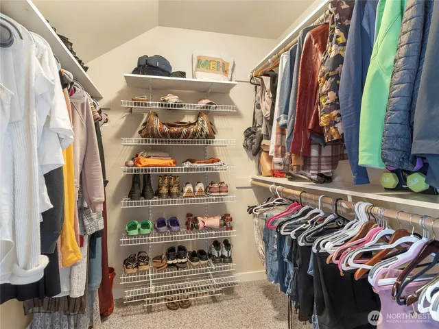a view of walk in closet with clothes and shoes