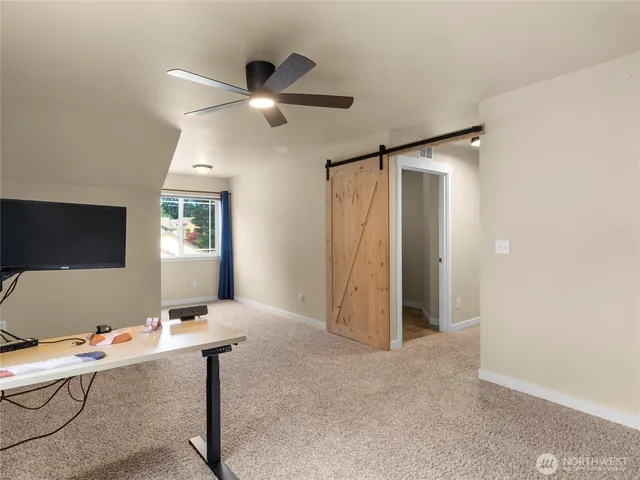 a view of a workspace with furniture and a window