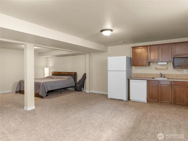 a utility room with a refrigerator a sink and cabinets