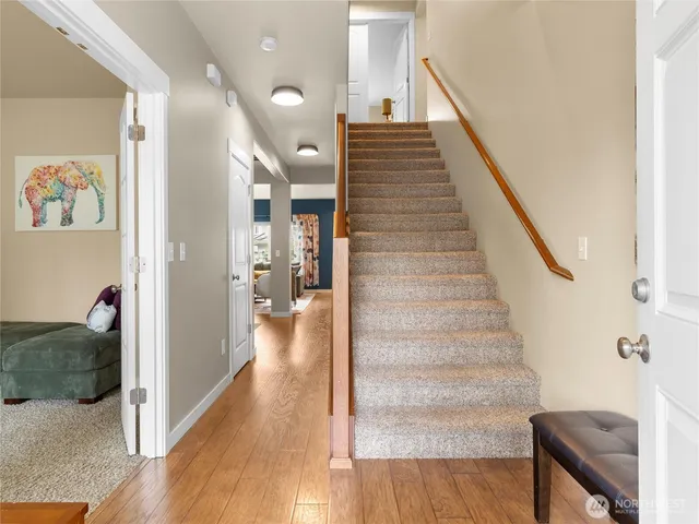 a view of a hallway with wooden floor and staircase