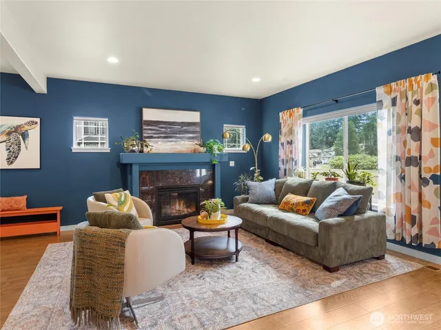 a living room with furniture fireplace and a large window