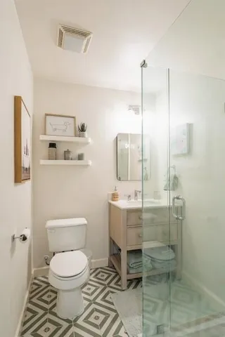 a bathroom with a toilet a sink and mirror