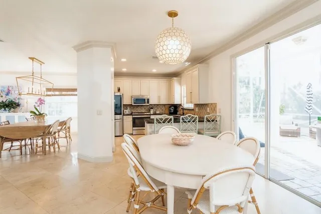 a view of a dining room and livingroom with furniture wooden floor a chandelier