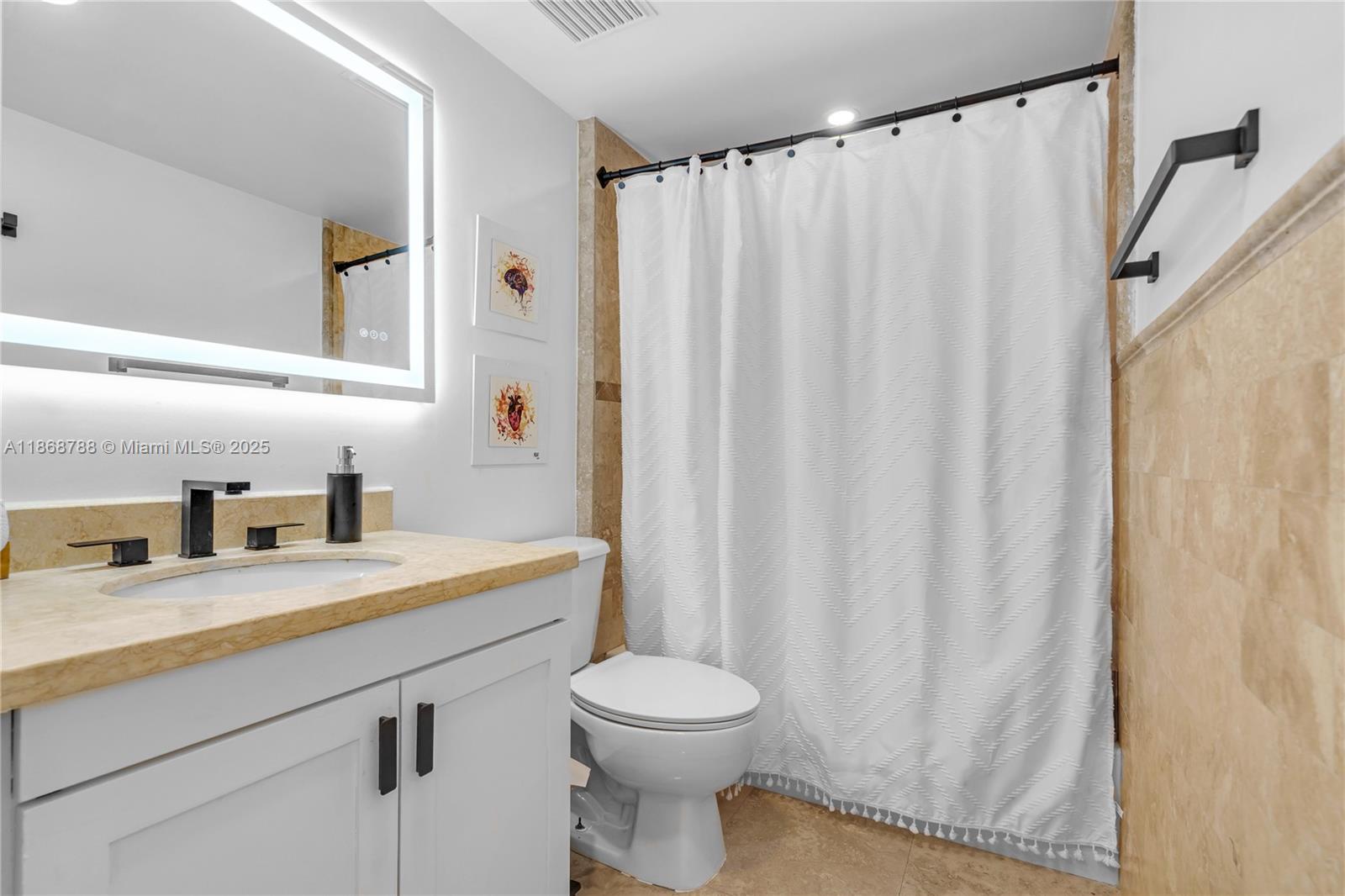 1723 Southwest 2nd Avenue, Unit 902 Miami, FL 33129 - Photo 13 of 33 a bathroom with a sink a toilet and a mirror