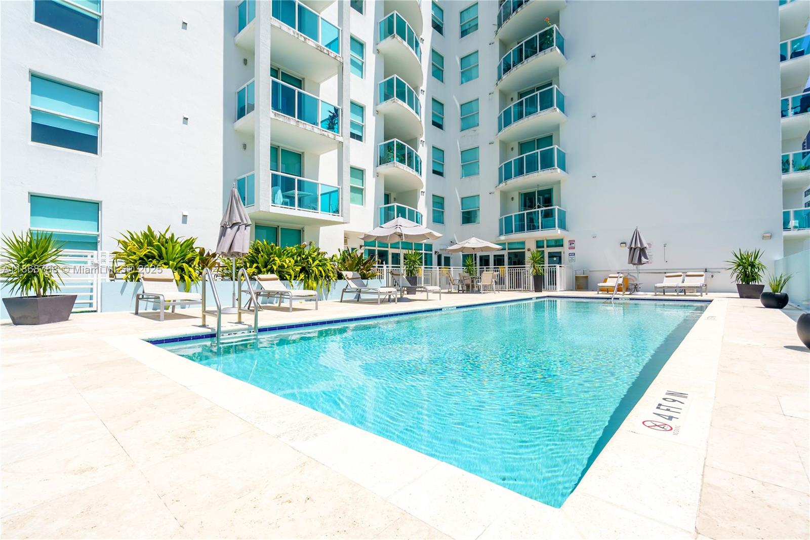 1723 Southwest 2nd Avenue, Unit 902 Miami, FL 33129 - Photo 28 of 33 a view of swimming pool with outdoor seating and house in the background