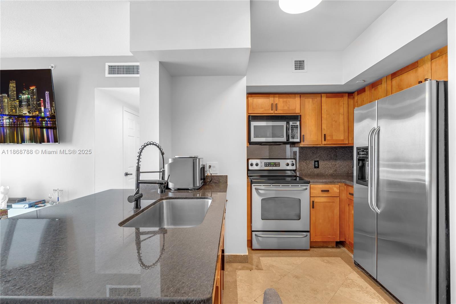 1723 Southwest 2nd Avenue, Unit 902 Miami, FL 33129 - Photo 7 of 33 a kitchen with stainless steel appliances granite countertop a sink a stove and a refrigerator