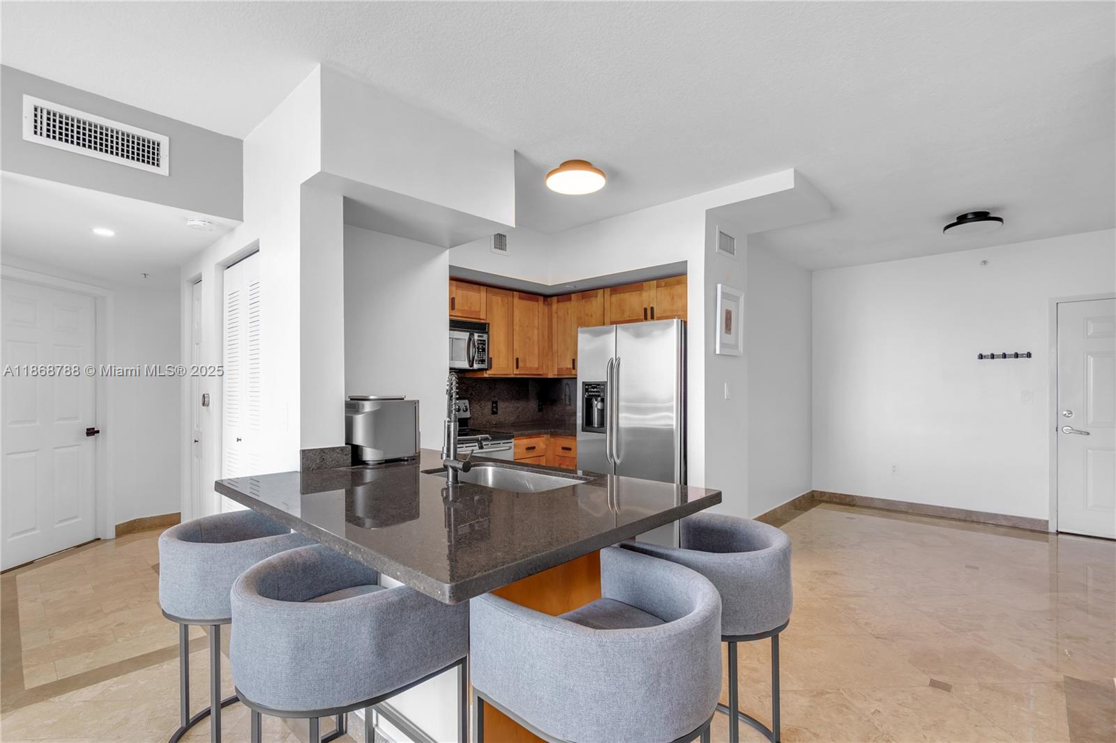 1723 Southwest 2nd Avenue, Unit 902 Miami, FL 33129 - Photo 10 of 33 a kitchen with granite countertop kitchen island stainless steel appliances a table and chairs