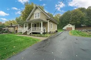 a front view of a house with a yard and trees