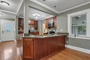 a kitchen with kitchen island granite countertop a sink window and wooden floor