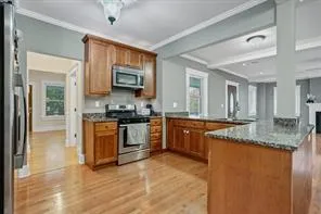 a kitchen with granite countertop a stove top oven a sink a counter space and cabinets