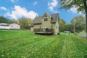 a view of a house with a big yard and large trees