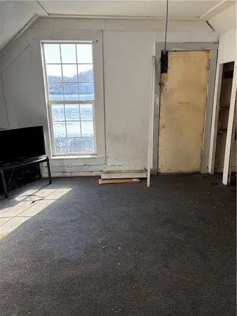 a view of empty room with a flat screen tv and a window